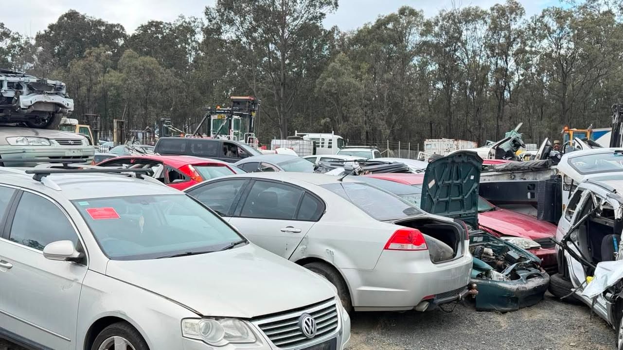 Line-up of old Australian cars and utes waiting for free scrap removal